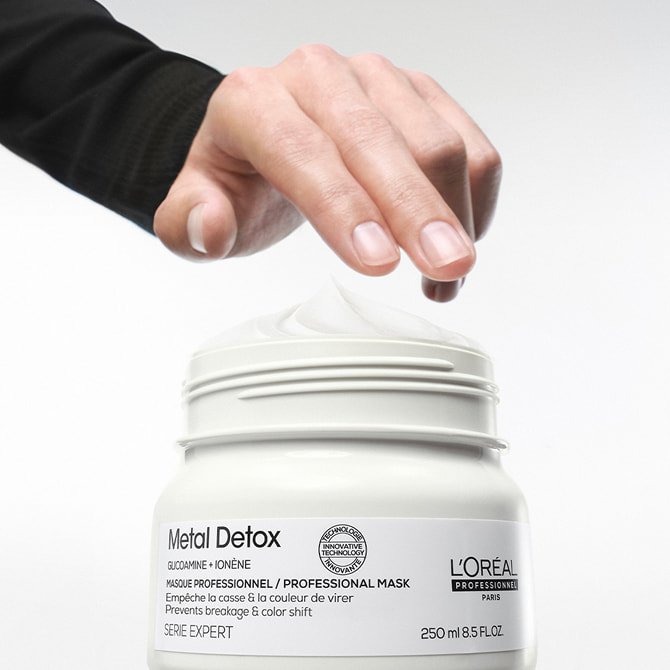 Hand dipping into a professional hair mask for every type of hair to prevent breakage and maintain vibrant salon color.&nbsp;