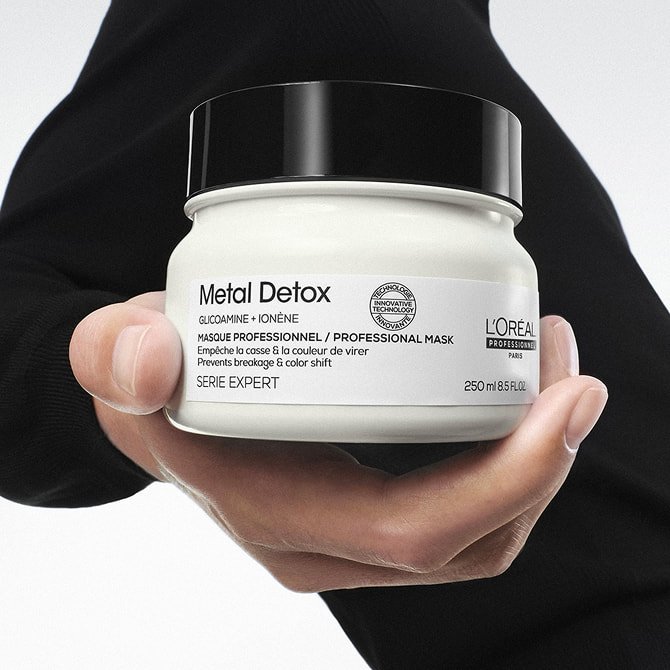 Holding a jar of hair mask for every type of hair designed to detoxify and protect fibers for a healthy and shiny finish.